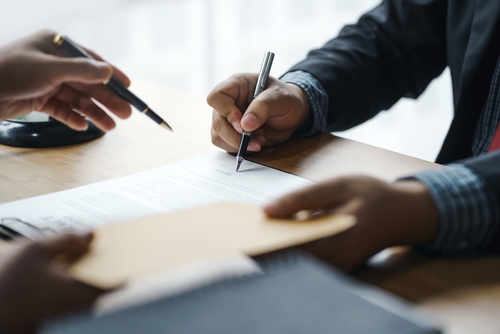 Two people signing an agreement