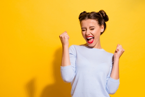 Woman smiling and happy with a yellow background